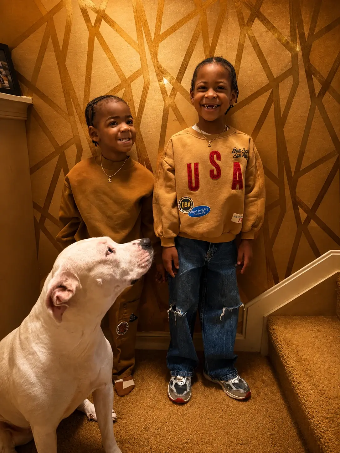 Two children standing with the family dog